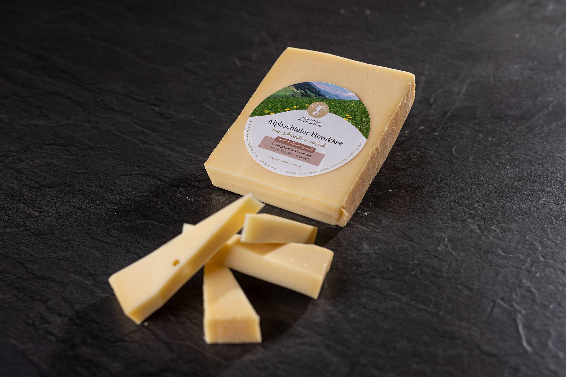 Hornkäse der Alpbachtaler Heumilchkäserei, daneben kleine Stücke
