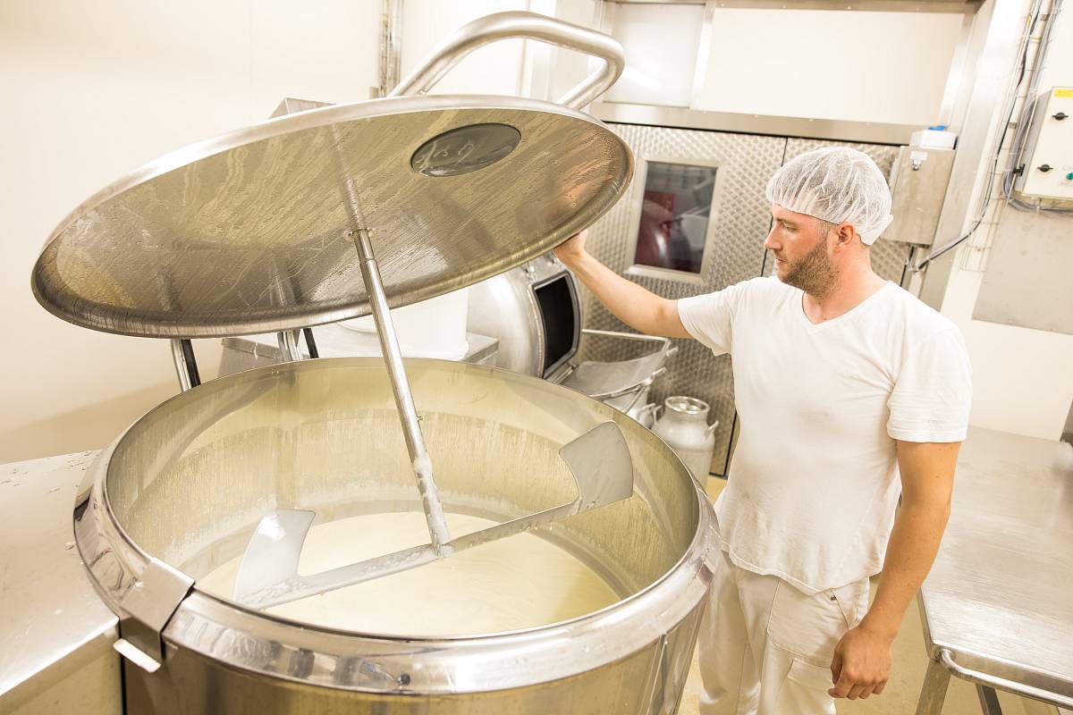 Ein Mann bei der Produktion von Käse