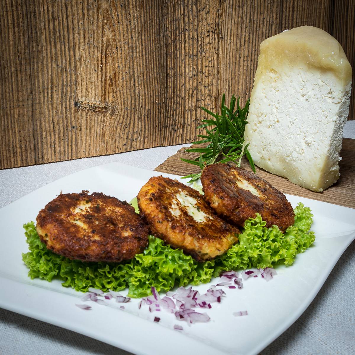 Gebackene Kaspressknödel auf einem Teller mit Salat
